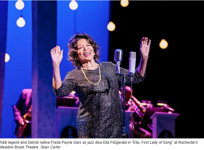 A woman singing into a microphone on a stage